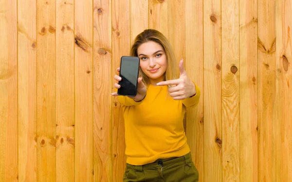 Jong Mooi Blond Vrouw Met Een Mobiele Telefoon Tegen Hout — Stockfoto