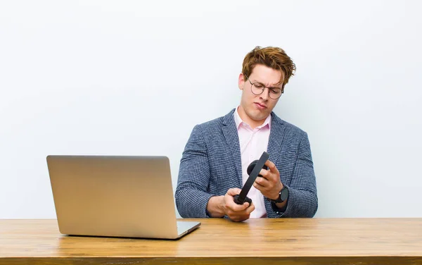 Jovem Empresário Cabeça Vermelha Trabalhando Sua Mesa Com Fones Ouvido — Fotografia de Stock