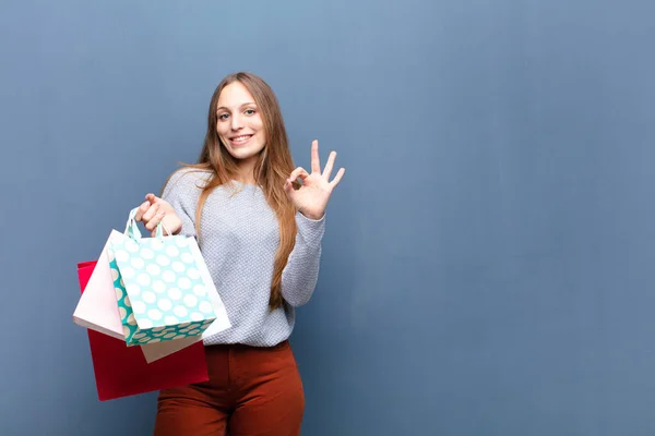 Joven Bonita Mujer Con Bolsas Compras Contra Pared Azul Con —  Fotos de Stock