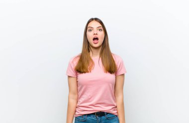 Genç ve güzel bir kadın korkmuş ve şok olmuş hissediyor, ağzı açık beyaz arka plana karşı şaşkınlık içinde.