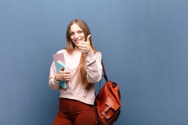 Kitapları ve çantasıyla genç ve güzel bir kız öğrenci.