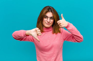 Genç, güzel bir kadın, kafası karışık, bilgisiz ve kararsız hissediyor, iyi ve kötü seçenekleri ya da mavi arka plandaki seçenekleri tartıyor.