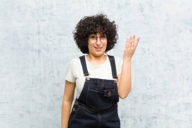Genç, güzel afro kadın mutlu, şaşkın ve neşeli, pozitif bir tavırla gülümseyen, bir çözüm ya da fikir gerçekleştiren