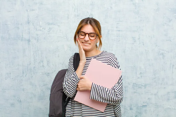 頬を持って痛みを伴う歯痛を抱える若い女子学生気分が悪く惨めで不幸な歯医者を探して — ストック写真