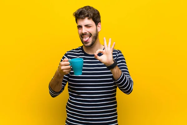 Jovem bonito homem tendo um café contra fundo laranja — Fotografia de Stock