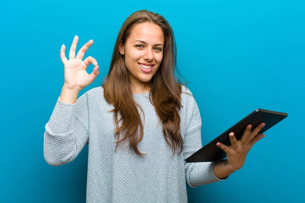 Junge Frau mit Tablet vor blauem Hintergrund — Stockfoto