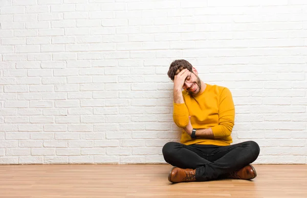 Junger Gutaussehender Mann Sitzt Auf Dem Fußboden Vor Einer Ziegelwand — Stockfoto