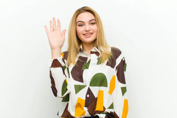 Young Blonde Woman Smiling Happily Cheerfully Waving Hand Welcoming Greeting — ストック写真