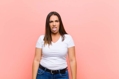 Genç, güzel, İspanyol bir kadın tiksinmiş ve rahatsız olmuş hissediyor. Dilini dışarı çıkarıyor. Pis ve iğrenç bir şeyden hoşlanmıyor.