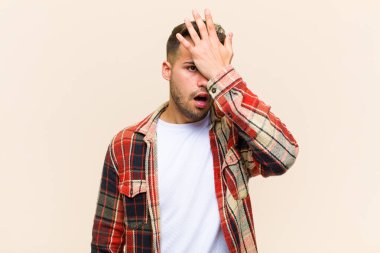 Genç İspanyol bir adam, aptalca bir hata yaptıktan ya da hatırladıktan sonra kendini izole edilmiş arka planda aptal gibi hissederek avuçtan avuca kadar yükseltiyor.