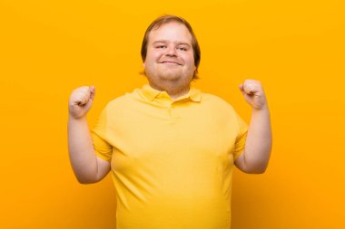 Son derece mutlu ve şaşırmış görünüyor, başarıyı kutluyor, bağırıyor ve zıplıyor.