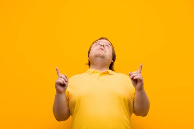 Şaşırmış, şaşırmış ve ağzı açık bir şekilde iki eliyle uzayı kopyalamak için yukarı bakıyor.