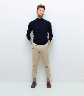 Genç bedenci kendini şaşkın ve şüpheci hissediyor, merak ediyor ya da beyaz arka planda bir karar vermeye çalışıyor.