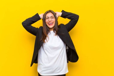 Genç, güzel bir kadın mutlu, kaygısız, arkadaş canlısı ve rahat görünüyor. Turuncu duvara karşı olumlu bir tavırla hayattan ve başarıdan zevk alıyor.