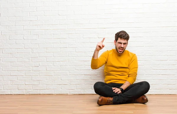 Jonge Knappe Man Zitten Vloer Tegen Baksteen Muur Textuur — Stockfoto