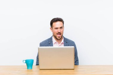 Genç yakışıklı iş adamı korkmuş ve şok olmuş hissediyor, ağzı açık ve şaşkınlık içinde.