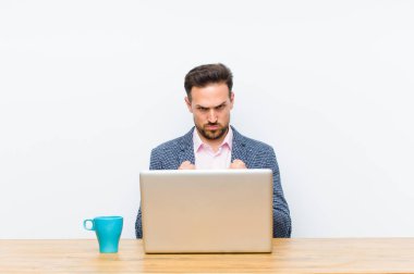 Genç yakışıklı iş adamı kendinden emin, sinirli, güçlü ve agresif görünüyor. Yumrukları boks pozisyonunda dövüşmeye hazır.