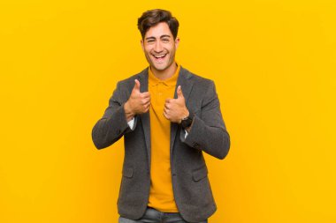  Gülümseyen mutlu, pozitif, kendinden emin ve başarılı, iki başparmağı da havada.