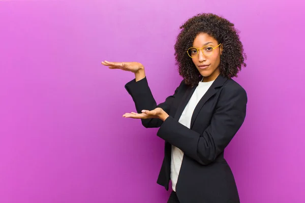 Joven Mujer Negocios Negra Sosteniendo Objeto Con Ambas Manos Espacio —  Fotos de Stock