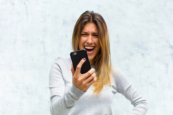 Giovane Bella Donna Con Uno Smartphone Contro Muro Grunge — Foto Stock