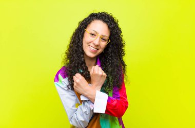 Genç ve güzel bir kadın sevinçle gülümsüyor ve kollarını kavuşturup, kollarını kavuşturup, kroma anahtarına karşı mutlu ve pozitif hissediyor.