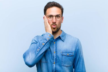 Genç yakışıklı adam şok olmuş ve ağzı açık halde yüz yüze inanamamaktan şaşkına dönmüş durumda.