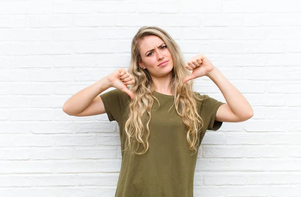 Jong Blond Vrouw Kijken Verdrietig Teleurgesteld Boos Tonen Duimen Naar — Stockfoto