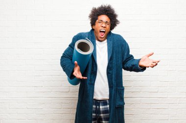 Yoga minderli pijama giyen genç bir zenci. 