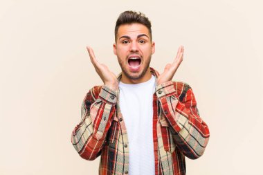 Genç İspanyol adam şok olmuş ve heyecanlı, gülüyor, şaşırmış ve mutlu çünkü izole edilmiş arka plana karşı beklenmedik bir sürpriz