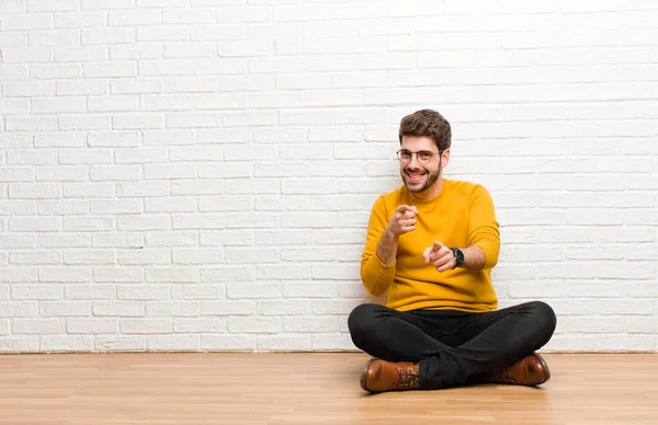Junger Gutaussehender Mann Sitzt Auf Dem Fußboden Vor Einer Ziegelwand — Stockfoto