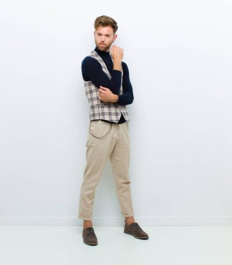 Genç adam beyaz arka planda poz veriyor.