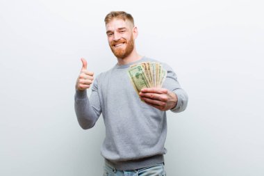 beyaz arka plan karşı dolar ile genç kırmızı kafa adam