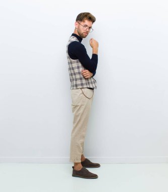 Genç adam beyaz arka planda poz veriyor.