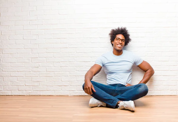 若い黒人男性は幸せそうに手をつないで笑顔で家の床に座って肯定的で誇りと友好的な態度 — ストック写真