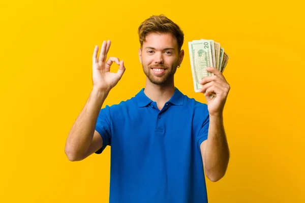 Jeune Homme Avec Des Billets Sur Fond Orange — Photo