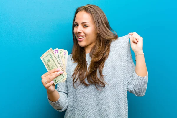 Jonge vrouw met rekeningen tegen blauwe achtergrond — Stockfoto