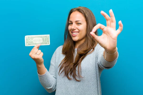 Mladá žena s účty na modrém pozadí — Stock fotografie