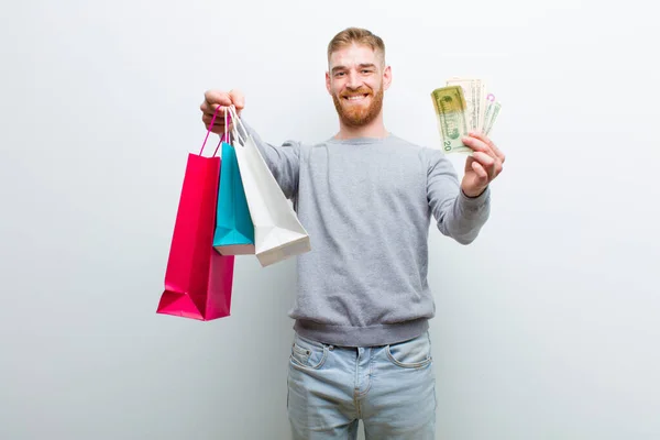 Junger Roter Mann Mit Einkaufstüten Vor Weißem Hintergrund — Stockfoto