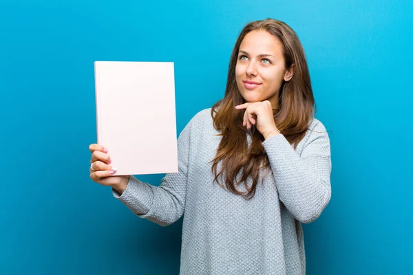 Jonge vrouw met een notebook tegen blauwe achtergrond — Stockfoto