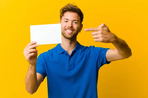 Young Man Holding Placard Orange Background — Stock Photo, Image