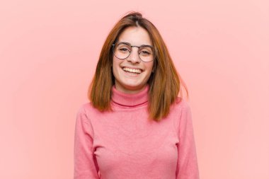 Genç ve güzel bir kadın mutlu ve hoş bir şekilde şaşırmış görünüyor. Pembe arka plana karşı büyüleyici ve şok edici bir ifadeyle heyecanlanıyor.