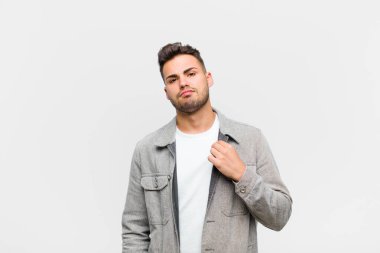 Genç İspanyol adam kibirli, başarılı, pozitif ve gururlu görünüyor, gri arka planda kendini gösteriyor.