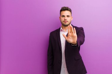 Genç İspanyol adam ciddi, sert, hoşnutsuz ve kızgın görünüyor.