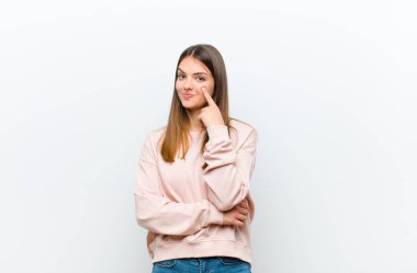 Genç ve güzel bir kadın sana göz kulak oluyor, güvenmiyor, izliyor ve beyaz arka plana karşı tetikte oluyor.