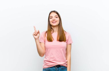 Genç ve güzel bir kadın bir fikri fark ettikten sonra mutlu ve heyecanlı bir dahi gibi hissediyor, neşeli bir şekilde parmağını kaldırıyor, eureka! beyaz arkaplan