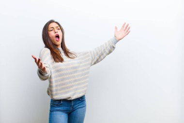 Genç, güzel bir kadın opera yapıyor ya da konserde şarkı söylüyor. Romantik, sanatsal ve tutkulu bir şekilde beyaz duvara yaslanmış.