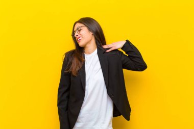 Genç, güzel bir kadın endişeli, hasta, hasta ve mutsuz hissediyor. Ağrılı bir mide ağrısı ya da turuncu duvarda grip geçiriyor.