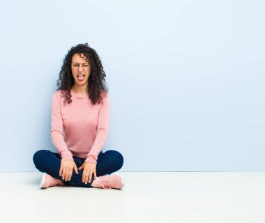 Genç, güzel bir kadın, tiksinmiş ve rahatsız olmuş hissediyor. Dilini dışarı çıkarıyor. Çirkin ve iğrenç bir şeyden hoşlanmıyor.