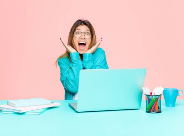 Genç ve güzel bir kadın dizüstü bilgisayarla çalışıyor. Şaşırmış, heyecanlı, gülen, şaşırmış ve mutlu hissediyor. Çünkü beklenmedik bir sürpriz.