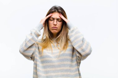 Genç ve güzel bir kadın stresli ve hayal kırıklığına uğramış görünüyor. Baskı altında çalışıyor ve beyaz arka planda sorunlar yaşıyor.